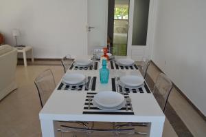 卡斯卡伊斯Alegre Apartamento的一张带椅子的白色桌子和一个花瓶