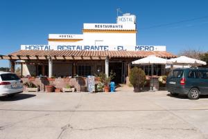扎霍拉Hostal Cafeteria El Mero的两辆汽车停在餐厅前的停车场