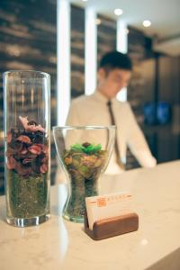 高雄金石大饭店的一张带花卉玻璃花瓶的桌子和一张卡