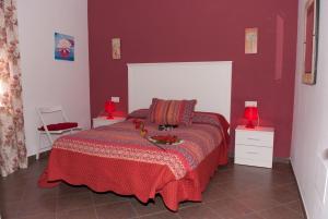 扎霍拉Viviendas Turísticas El Mero的一间卧室配有一张红色墙壁的床和两盏灯。
