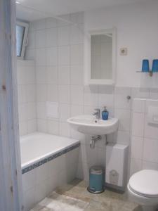 BrösaFerienwohnung Alte Brennerei的白色的浴室设有水槽和卫生间。