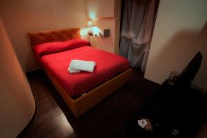 BovinoLa Casetta di Nonna Carmela的小卧室配有红色的床和毛巾
