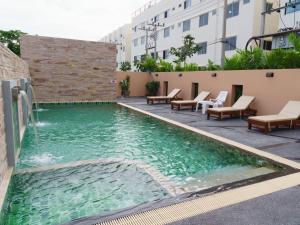 华欣VISA Hotel Hua Hin - SHA Plus的一座建筑中间的游泳池,带喷泉
