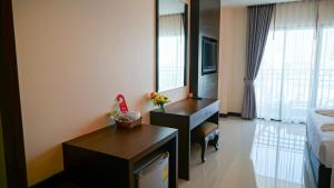华欣VISA Hotel Hua Hin - SHA Plus的酒店客房配有书桌和床。