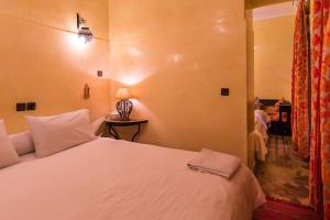 马拉喀什里亚德奥马尔庭院旅馆的卧室配有一张白色大床
