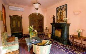 马拉喀什达艾尼文花园酒店&鸟类动物园 的客厅设有壁炉和壁炉。
