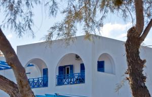 莫诺利索斯Rodothea and Adams on the Beach, Santorini的白色的建筑,拥有蓝色的窗户和树木