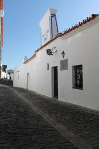 蒙萨拉什Casa Daterra的白色的建筑,上面有一个钟楼