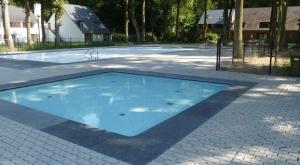 胡塔伦Domein Hengelhoef的砖地上的大型蓝色游泳池