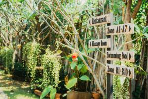 素可泰Pai Sukhothai Resort SHA Extra Plus的花园,有指示牌指向不同的方向