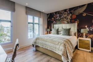 斯泰伦博斯多普街107号t精品酒店的一间卧室设有一张带花卉墙壁的大床