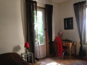 滨海拉塞讷La Mandarinette的一间卧室配有一张床、一张书桌和一个窗户。