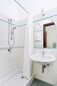 卡普里大乔治酒店的白色的浴室设有水槽和镜子