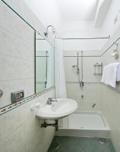 卡普里大乔治酒店的白色的浴室设有水槽和浴缸。