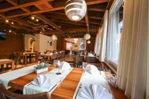 格吕施格鲁施酒店的用餐室配有带白色桌布和椅子的桌子