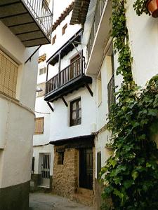 Casas del CastañarCasa Rural La Cueva的一条小巷,一条白色的建筑设有一个阳台