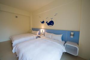 绿岛绿岛海洋之家民宿的两张睡床彼此相邻,位于一个房间里
