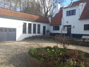 Wezembeek-Oppem罗斯马克住宿加早餐旅馆的白色的房子,有红色的屋顶和院子