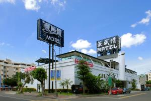 高雄薇風情汽車旅館 - 自由館的街道边有两个标志的汽车旅馆