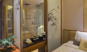 南昌南昌绿地华邑酒店的一间卧室设有淋浴、一张床和一个窗户。