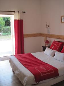 普洛默迪耶尔恩Le Relais de Porz Morvan的一间卧室配有一张带红色窗帘的大床