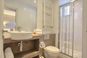 巴黎蒙迪酒店的浴室配有卫生间、盥洗盆和淋浴。