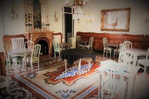 锡切斯夏雷特酒店的一间设有白色椅子、一张桌子和壁炉的房间