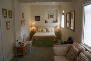 绍斯波特诺伍德宾馆的一间卧室配有一张床和一张沙发