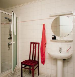 富伦庞思岱富伦酒店的一间带水槽、镜子和椅子的浴室