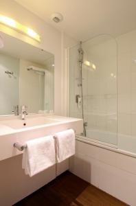 尚尼耶ibis Styles Angoulême Nord - hôtel restaurant的白色的浴室设有水槽和淋浴。