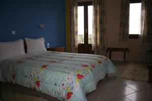 尼奥楚里翁Guesthouse Mitsiopoulou的一间卧室配有一张大床和色彩缤纷的被子
