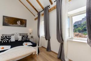 杜布罗夫尼克Dubrovnik Finest Apartments的卧室设有黑白床和窗户。
