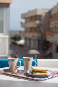埃斯普霍斯阿莱曼尼亚旅馆的盘子上放着两个杯子和三明治