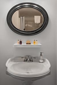 普罗温斯敦沃特福德旅馆的浴室水槽和上面的圆镜子