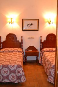 埃尔罗西奥托鲁诺餐厅及酒店的酒店客房设有两张床和一张桌子。