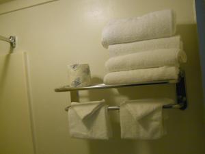 橡树溪Value Inn Motel - Milwaukee Airport South的浴室毛巾架上的一堆毛巾
