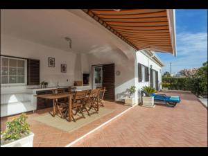 珀彻斯Villa Vilamar的一个带桌椅的庭院和一间厨房