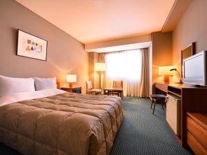 盛冈皇家盛岗酒店的酒店客房,配有床和电视