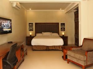 哲帕拉格科乡村旅馆的一间卧室配有一张床、一张桌子和一把椅子
