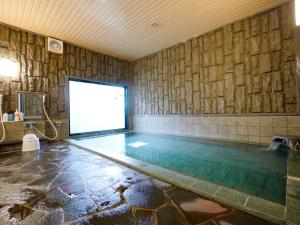 秋田秋田市土崎路线酒店的一个带屏风的游泳池,位于一个墙上的房间