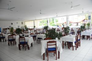 厄吕代尼兹卡贝尔海滩酒店的一间设有白色桌椅的用餐室