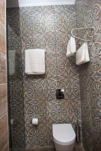 地拉那Hotel Boutique Restaurant Gloria的一间带卫生间和瓷砖墙的浴室