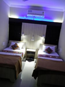那格浦尔Shivam Apartment的紫色灯房内的两张床