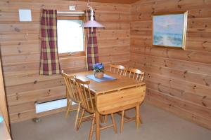 弗莱克菲尤尔Egenes Camping的一间带木桌和椅子的用餐室