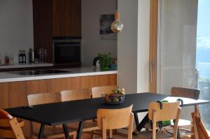 VellaPanoramic Ecodesign Apartment Obersaxen - Val Lumnezia I Vella - Vignogn I near Laax Flims I 5 Swiss stars rating的厨房配有黑色的桌子和椅子