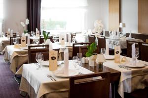 普图伊格兰德普利姆斯酒店 - 特尔梅普土伊 - 萨瓦酒店及度假村的用餐室配有桌椅和白色的桌布