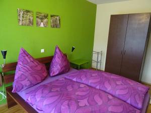 康斯坦茨舒尔特斯公寓的一间卧室配有紫色床和紫色枕头