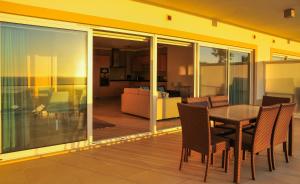 普拉亚德尔瑞伊Praia Del Rey SeaView Dupplex的一个带桌椅的阳台和一间客厅