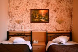 比雷埃夫斯伊莱克特拉比雷埃夫斯酒店的墙上画画的房间里设有两张床