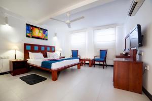 尼拉瓦利鸽子岛海滩度假村的一间卧室配有一张床和一台电视